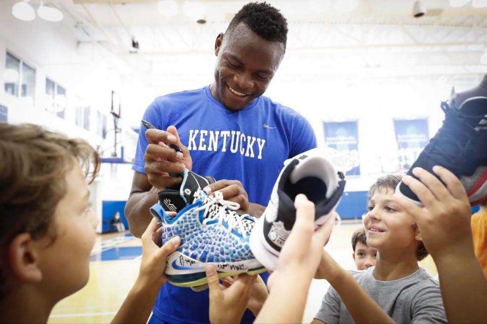 Kentucky basketball star Oscar Tshiebwe signs shoes for participants in a Wildcats basketball camp in the summer of 2021.