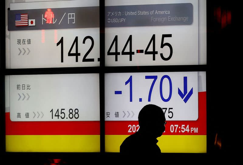 FILE PHOTO: A man is silhouetted in front of a board displaying the Japanese yen exchange rate against the U.S. dollar outside a brokerage, after Japan intervened in the currency market for the first time since 1998 to shore up the battered yen, in Tokyo