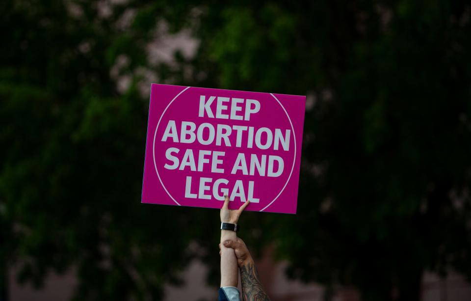 A sign is held during a protest in downtown  Fort Myers on Tuesday. Supporters and opponents of abortion rights were present. Members for abortion rights held the protest in response to a leaked draft opinion from the Supreme Court seeking to overturn Roe v. Wade. 