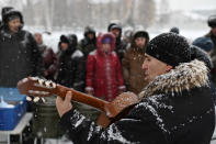 Un hombre toca la guitarra durante un evento organizado por Cáritas para ayudar a las personas sin hogar de Omsk. (Foto: Alexey Malgavko / Reuters).