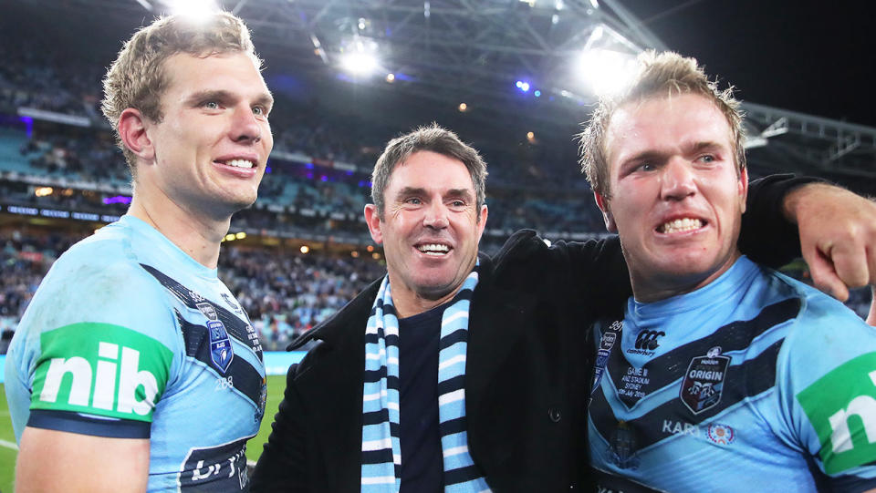 Blues coach Brad Fittler hugs and celebrates with Tom Trbojevic and Jake Trbojevic.