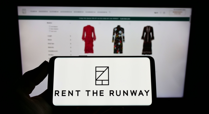 Person holding cellphone with logo of US e-commerce company Rent the Runway Inc on screen in front of business webpage Focus on phone display