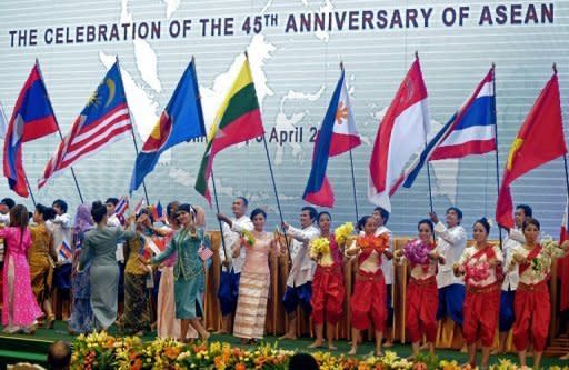 Performers carry flags of ASEAN member countries at its 20th summit in Phnom Penh. The group has called for Western sanctions against Myanmar to be lifted, as it holds talks also dominated by North Korea and maritime disputes with China