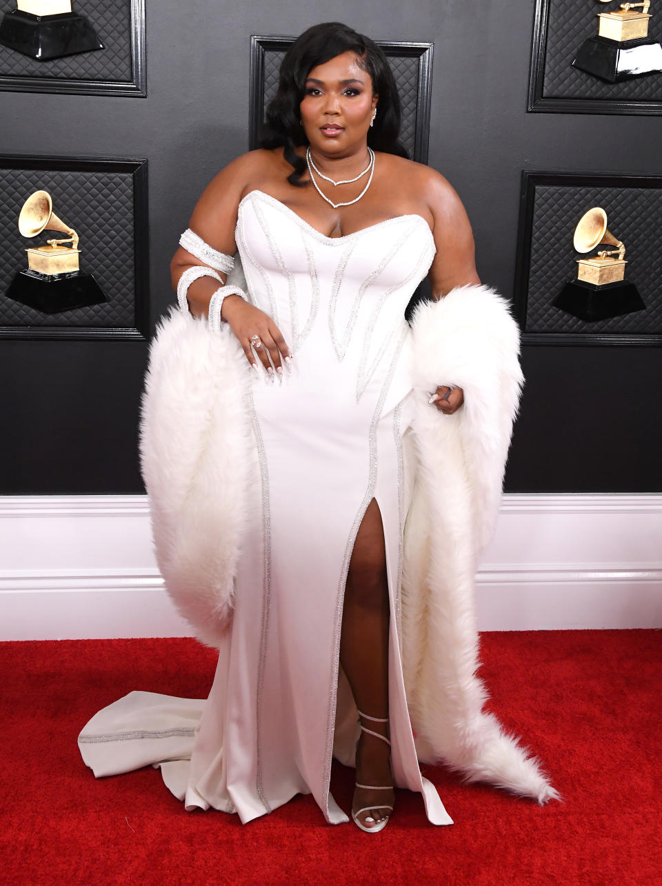 Die Sängerin Lizzo war an diesem Abend mit ihrem Album "Cuz I Love You" für acht Grammys nominiert. Auf dem roten Teppich glänzte sie in einer weißen Robe und Fake-Fur-Stola à la Hollywood-Diva. (Bild: Getty Images)