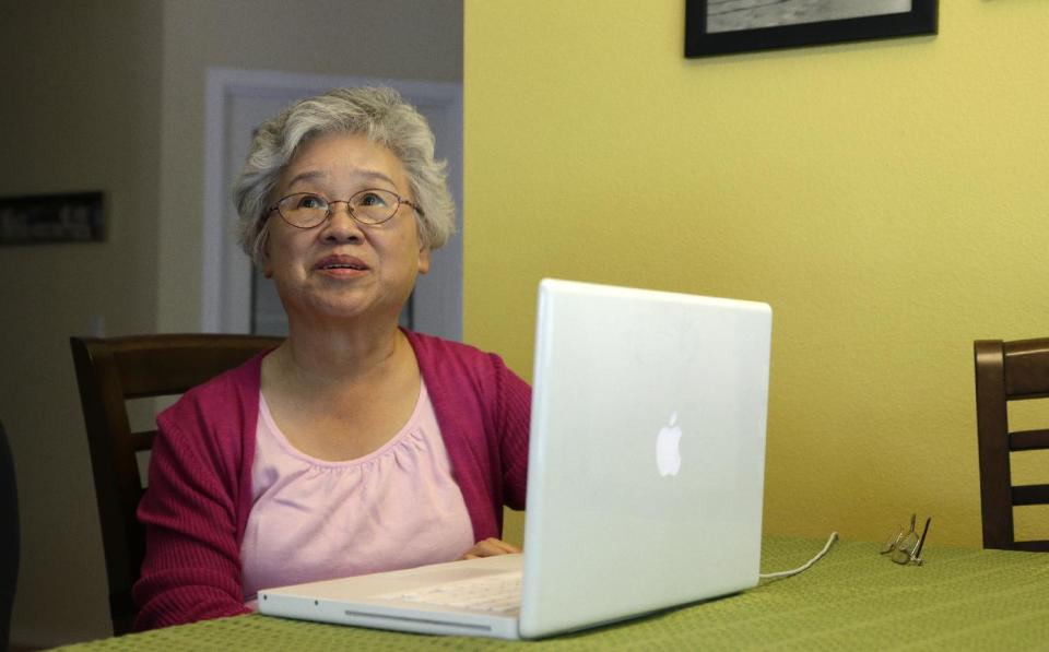FILE - This Aug. 7, 2013 file photo shows Myunghee Bae, the mother of Kenneth Bae, at her computer in her home in Lynnwood, Wash. The gallery over the House of Representatives is filling up for President Barack Obama’s State of the Union address. Democratic congressmen Rick Larsen of Washington and Charles Rangel of New York announced Tuesday they will host Myunghee Bae. (AP Photo/Ted S. Warren, File)