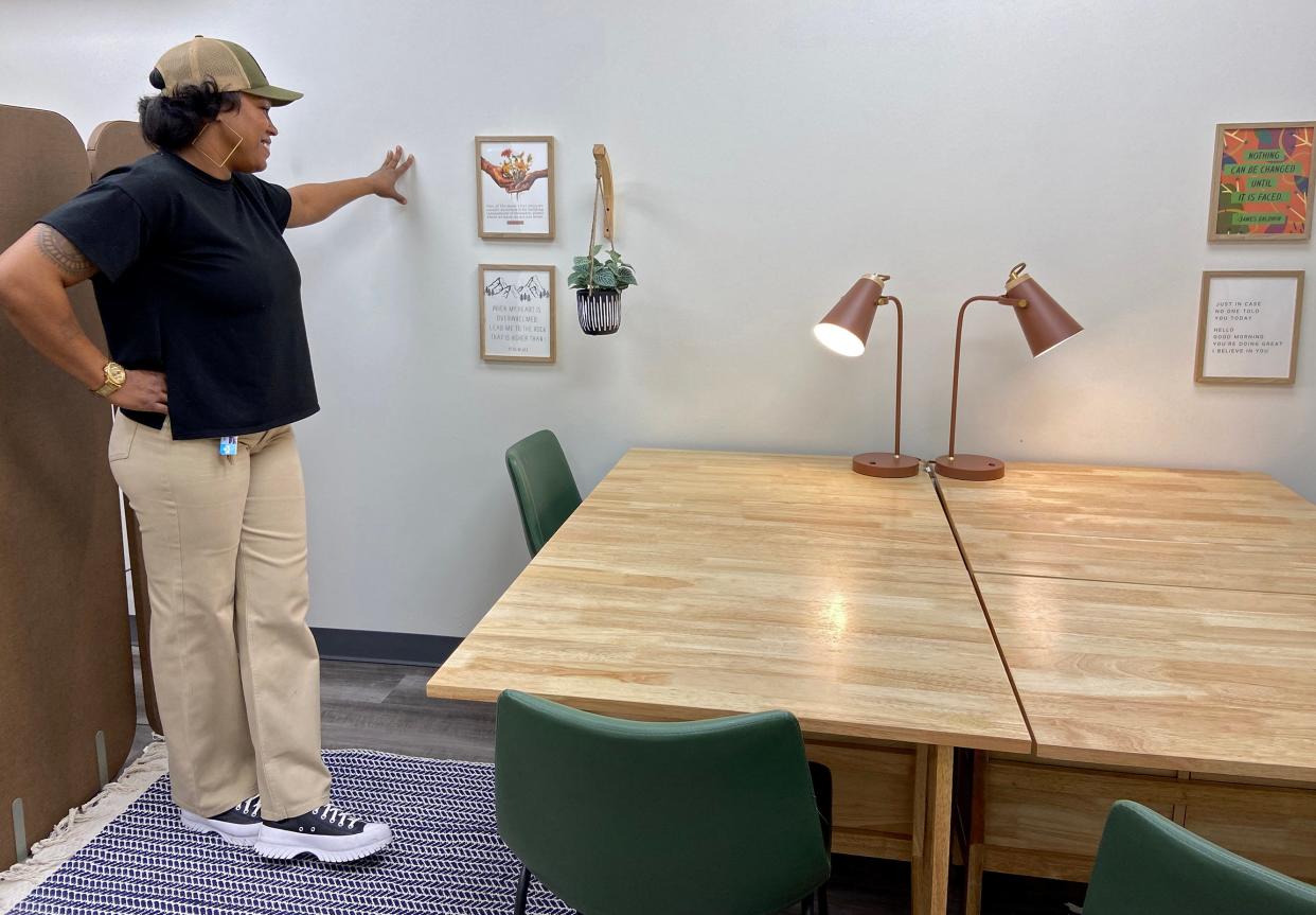 Brandy Jones, manager at The Market at Eastpoint, reads inspirational messages featured on the walls of the new Bank of America Community Resource Room at the store, 1708 NE 23.