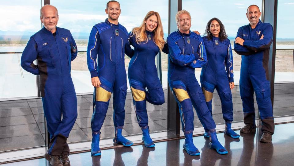 Richard Branson and a group of astronauts in Blue suits