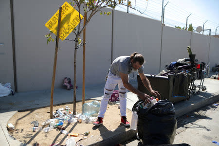 Daniel McMillan, 45, who has been homeless for 20 years, collects bottles to sell on the street where he lives in Los Angeles, California, U.S. March 29, 2018. Picture taken March 29, 2018. REUTERS/Lucy Nicholson