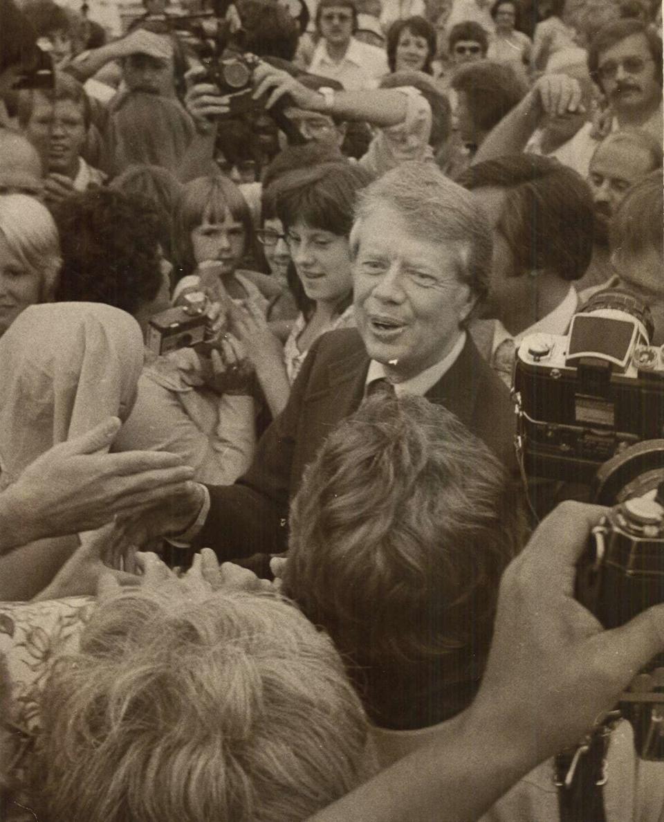 Democratic presidential candidate Jimmy Carter reaches out to shake the hand of a welcomer in the crowd at the Des Moines Municipal Airport on Aug. 25, 1976.