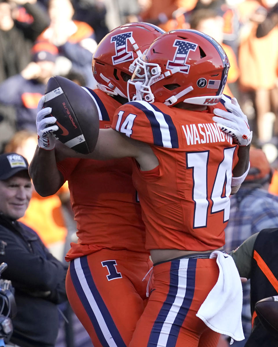 Illinois wide receiver Isaiah Williams, left, celebrates his game winning touchdown with wide receiver Casey Washington during the overtime period of an NCAA college football game against Indiana Saturday, Nov. 11, 2023, in Champaign, Ill. Illinois won 48-45. (AP Photo/Charles Rex Arbogast)