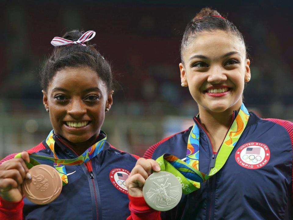 Simone Biles (left) and Laurie Hernandez pose with their medals from the 2016 Olympics balance beam event.