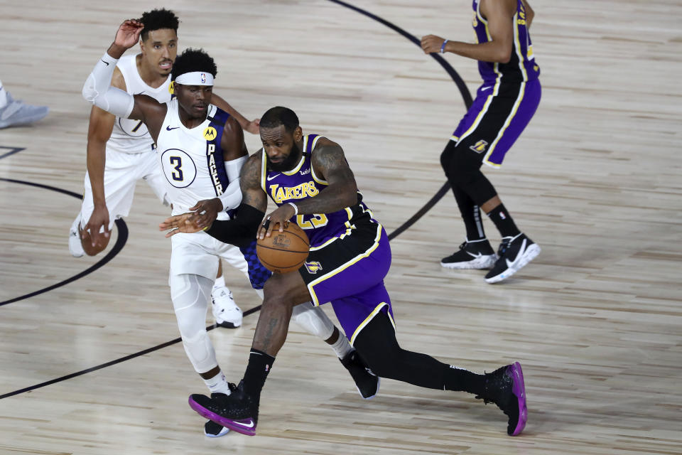 Los Angeles Lakers forward LeBron James (23) drives to the basket against Indiana Pacers guard Aaron Holiday (3) during the fourth quarter of an NBA basketball game Saturday, Aug. 8, 2020, in Lake Buena Vista, Fla. (Kim Klement/Pool Photo via AP)