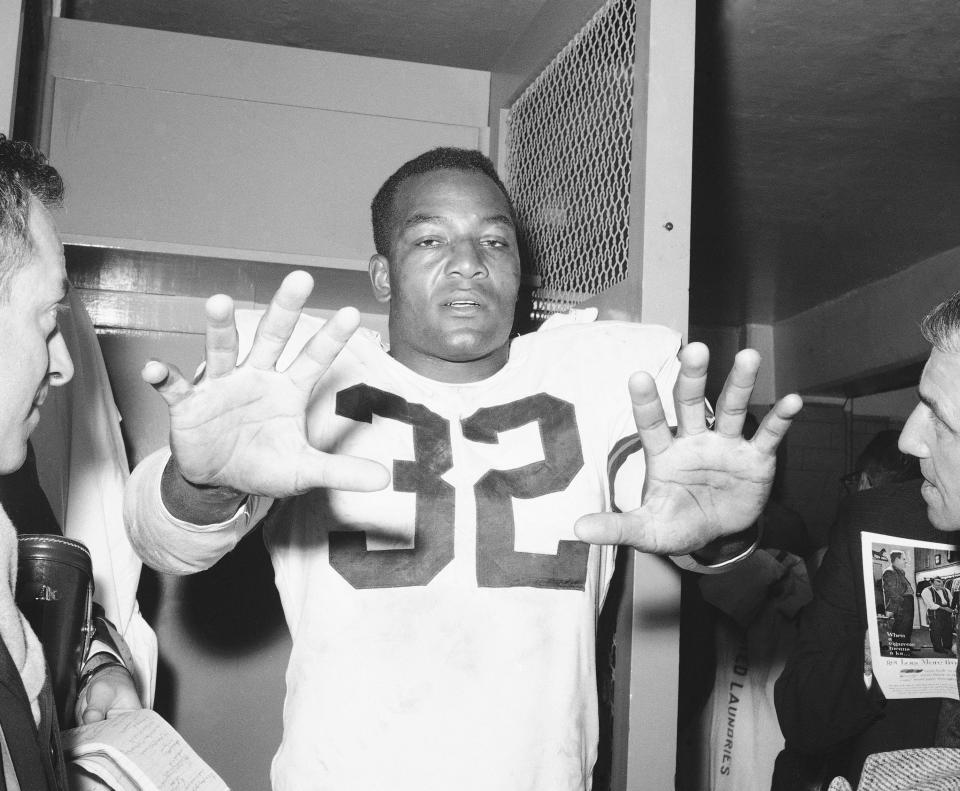 Jim Brown of the Cleveland Browns displays his sure hands in the dressing room at New York's Yankee Stadium, Oct. 13, 1963, after beating the Giants. Brown scored three touchdowns and ran for 120 yards in 23 carries in the game, leaving him only 53 yards short of the NFL's career rushing record.