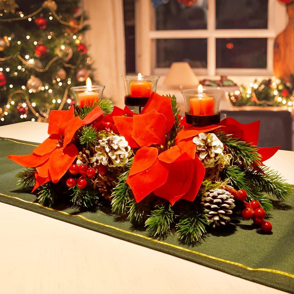 <p>La mesa ocupa un lugar central durante las fiestas decembrinas y con este centro de mesa con velas y flores de pascua le darás un colorido toque a tu cena navideña. Disponible en <a href="https://www.amazon.com/-/es/Centro-Navidad-portavelas-decoraci%C3%B3n-fiesta/dp/B09B3ZH3GX/ref=sr_1_12?__mk_es_US=%C3%85M%C3%85%C5%BD%C3%95%C3%91&crid=3RZWUZUQEFJ0R&keywords=christmas+candle+centerpieces+for+dining+table&qid=1638195742&qsid=134-7998215-4139162&sprefix=christmas+candle+centerpiece%2Caps%2C221&sr=8-12&sres=B08GBPW7KR%2CB0994H5NTH%2CB074K8MDL5%2CB0978XDT2R%2CB08LDCCVSR%2CB08HS1YYNT%2CB01IMYIY2Q%2CB01G2V65VS%2CB07WXGW4RK%2CB01MQG41D1%2CB09B3ZH3GX%2CB099WYNBGF%2CB09B9VJCPR%2CB01IMYISBI%2CB09J1XT8Q3%2CB001QUQ070%2CB08HRYJT19%2CB08NYP635P%2CB00X469DRI%2CB015DU4VSI&srpt=CANDLE_HOLDER" rel="nofollow noopener" target="_blank" data-ylk="slk:Amazon;elm:context_link;itc:0;sec:content-canvas" class="link ">Amazon</a> por $29.98</p>