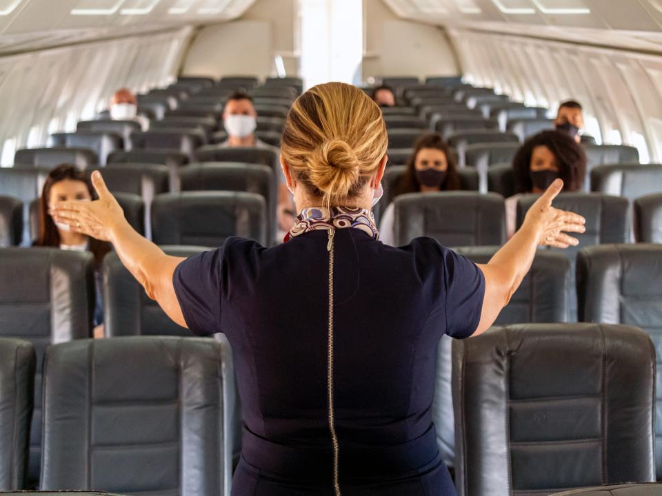 A flight attendant addressing passengers.