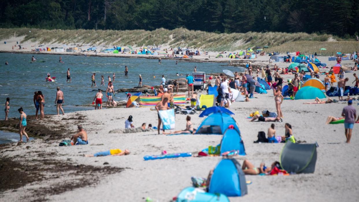 Menschen am Strand von Lubmin. Viele Ostseebäder machen derzeit mit Aushängen auf die Gefahr durch Vibrionen aufmerksam.