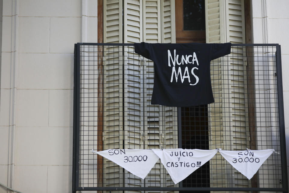 The Spanish messages "They are 30,000," referring to the number of people who disappeared during the last dictatorship, "Judgment and punishment," and "Never again" hang from a balcony on handkerchiefs and a T-shirt in Buenos Aires, Argentina, Tuesday, March 24, 2020. Today marks the anniversary of the military coup that led to the 1976-83 dictatorship, but as people are not allowed to march due to the government's lockdown to help contain the spread of the coronavirus, people are finding other ways to mark the day. (AP Photo/Natacha Pisarenko)