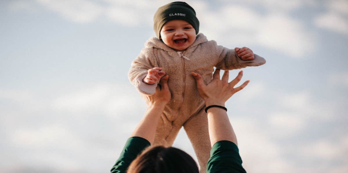 woman throwing baby in the air