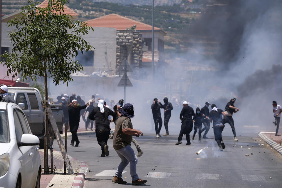 Druze protesters clash with Israeli police who fired tear gas as thousands took part in the demonstrations against the construction of massive wind turbines, in the Golan Heights, Wednesday, June 21, 2023. Police fired tear gas, sponge-tipped bullets and a water canon during the mass demonstrations by Druze Arabs — a rare burst of violence in the normally quiet area. (AP Photo/Fadi Amun) **ISRAEL OUT**