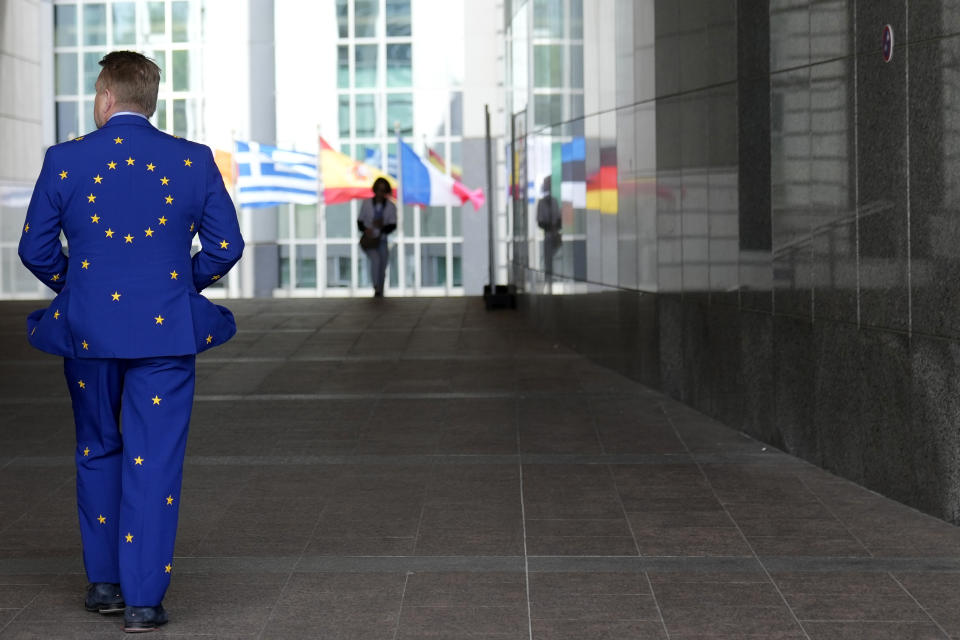 FILE - A man wears a suit in the EU colors as he walks outside the European Parliament during Europe Day celebrations in Brussels on May 4, 2024. The European Union marks Europe Day on Thursday, May 9, but instead of the traditionally muted celebrations, all eyes are on the EU elections in one month time which portend a steep rise of the extreme right and a possible move away from its global trendsetting climate policies. (AP Photo/Virginia Mayo, File)