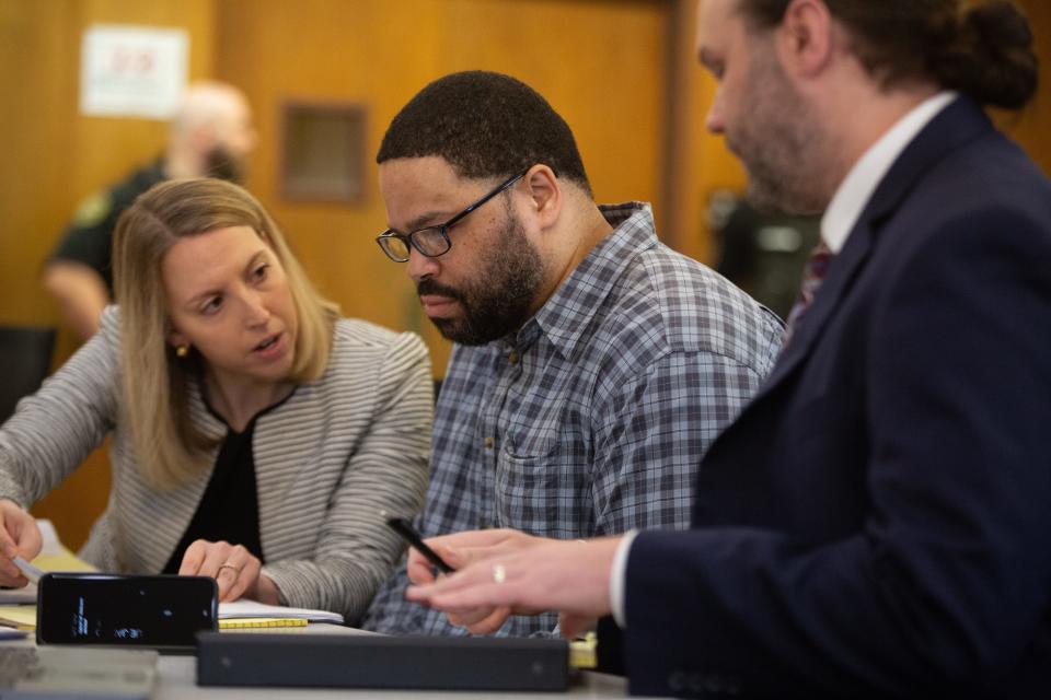 Defense attorney's Emily Barclay and Peter Conley consult with Yanez Sanford before the start of Tuesday's trial at the Shawnee County Courthouse.