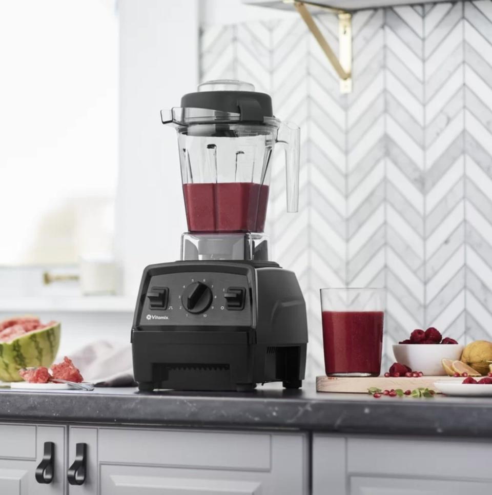 the blender sitting on counter with fruit smoothie