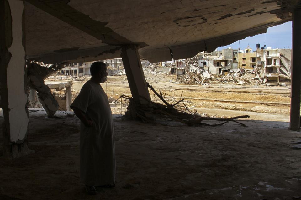 FILE - Flood survivor Abdul Salam Anwisi looks at the destroyed homes following flooding caused by Mediterranean storm Daniel, in Derna, Libya, Sept. 17, 2023. This year’s COP28 in Dubai is likely to see more discussion about compensation for developing nations harmed by climate change. (AP Photo/Yousef Murad, File)