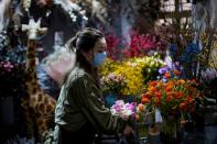 Florist Wang Haiyan, 41, works among flowers inside her shop as the country is hit by an outbreak of the new coronavirus, in Shanghai