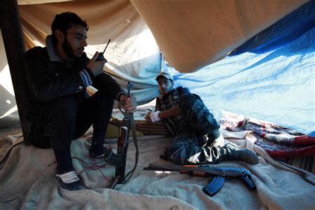 Free Syrian Army fighters rest as one of them uses a talkie-walkie near the the Kwers military airport, where forces loyal to Syria's President Bashar al-Assad are based, in Aleppo September 9, 2013. REUTERS/Loubna Mrie