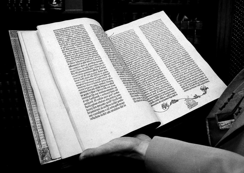 ARCHIVO - Un empleado de Christie's muestra uno de los dos volúmenes de la Biblia de Gutenberg impresa en piel animal, propiedad del Seminario Teológico General de la Iglesia episcopal, a subastarse en la ciudad de Nueva York, el 1 de abril de 1978. (AP Foto/G. Paul Burnett, Archivo)