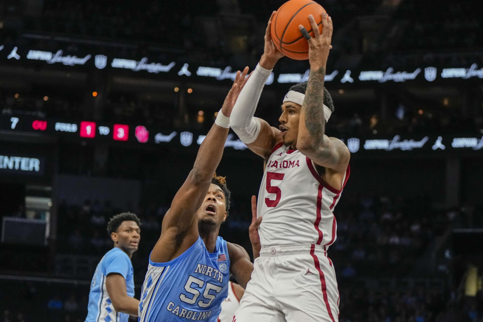 Oklahoma guard Rivaldo Soares drives to the basket past North Carolina forward Harrison Ingram during the first half of an NCAA college basketball game Wednesday, Dec. 20, 2023, in Charlotte, N.C. (AP Photo/Chris Carlson)