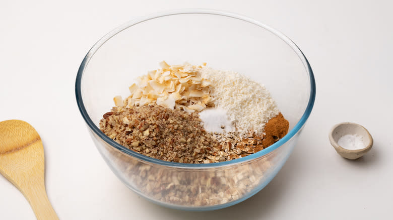 mixing dry granola ingredients in glass bowl