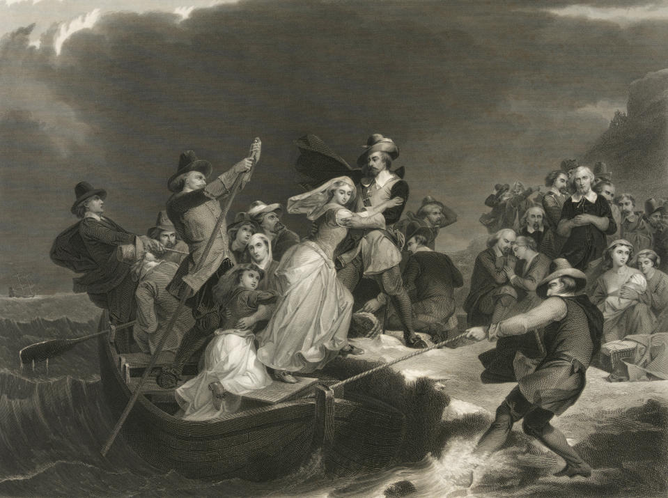 This circa 1869 engraving titled "Landing of the Pilgrims on Plymouth Rock, 1620" made available by the Library of Congress depicts a woman being helped ashore from a small boat held in position against a rock by men with ropes and poles. At background right, other Pilgrims kneel in prayer. (Peter Frederick Rothermel, Joseph Andrews/Library of Congress via AP)