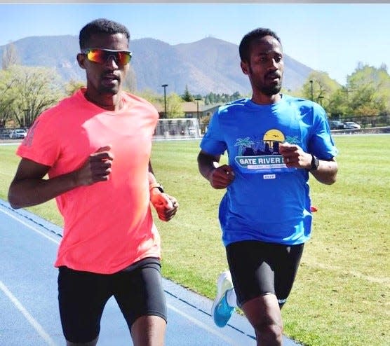 Futsum Zienasellassie, right, trains with Eritrean runner Tsegay Tumay in Flagstaff, Ariz.