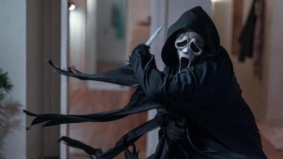 a ghostface with a weathered mask slices at an object in scream vi