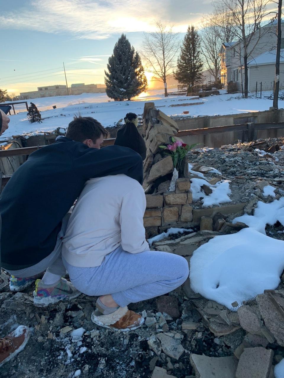 Greysen and Peyton Carter survey damage from the Marshall Fire at their family home in Louisville, Colo.