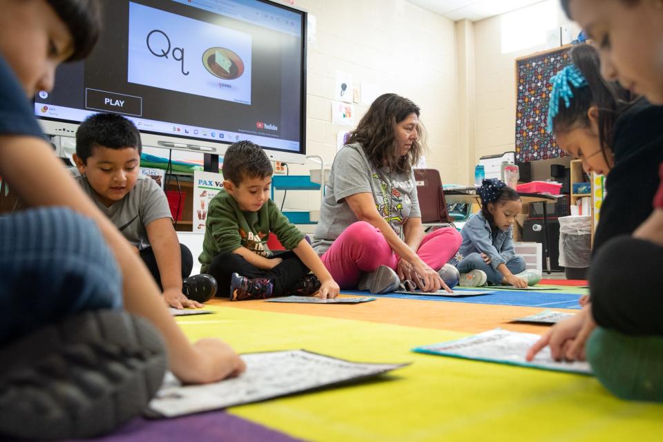 From center left, Mario Castro, Andres Villaseñor Diaz, teacher Elizabeth Barger and Sofia Briones practice the Spanish alphabet during class, Dec. 8 2023, in Corpus Christi, Texas.