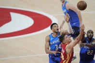 Atlanta Hawks' Bogdan Bogdanovic (13) rebounds the ball against Milwaukee Bucks' Khris Middleton (22) and Giannis Antetokounmpo (34) during the first half of Game 3 of the NBA Eastern Conference basketball finals Sunday, June 27, 2021, in Atlanta. (AP Photo/Brynn Anderson)