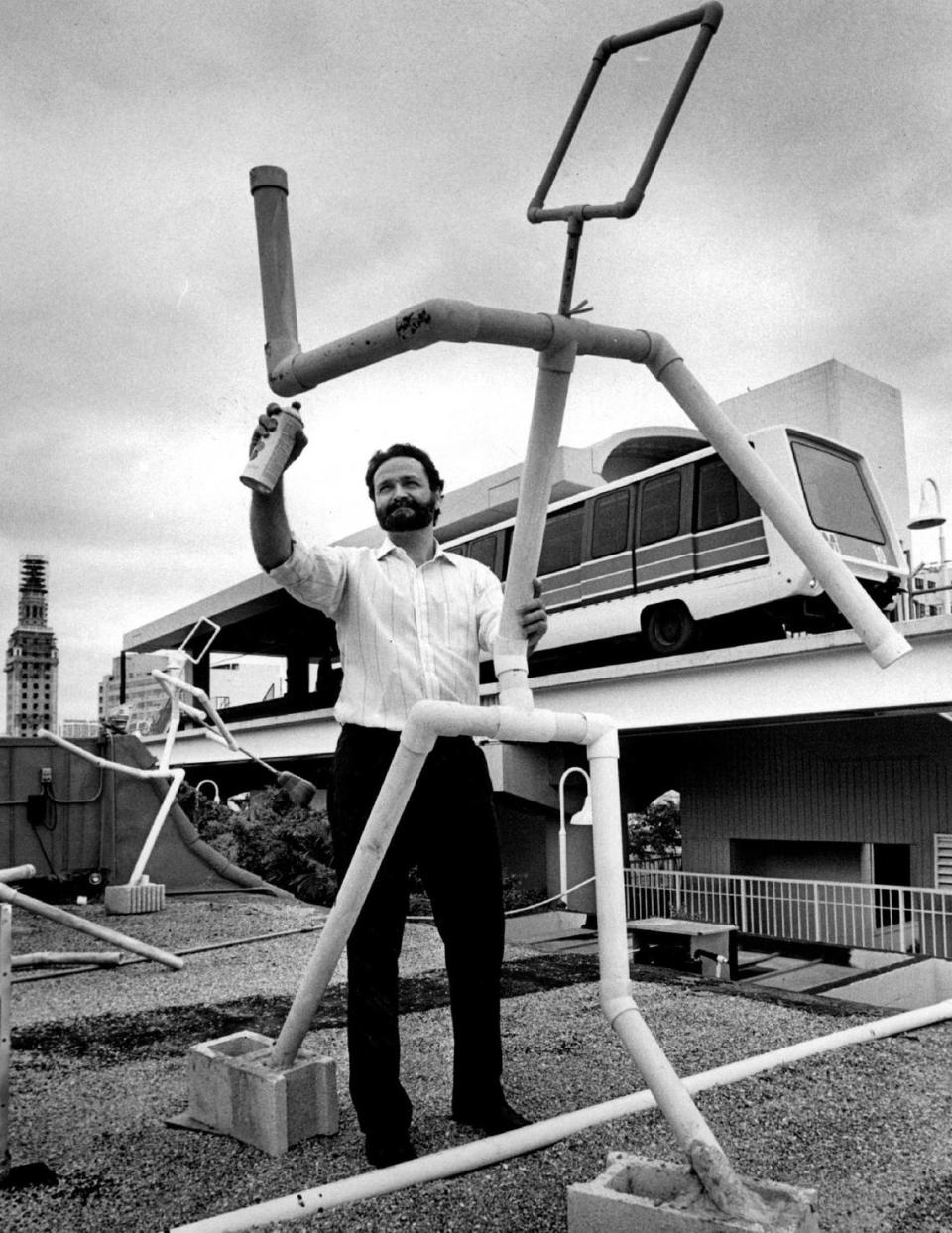 In 1988, downtown advocate Carlos Batista spray paints stick figure sculptures that will be part of the Light up Miami. The art, on top of downtown buildings, is for the benefit of Metromover riders.