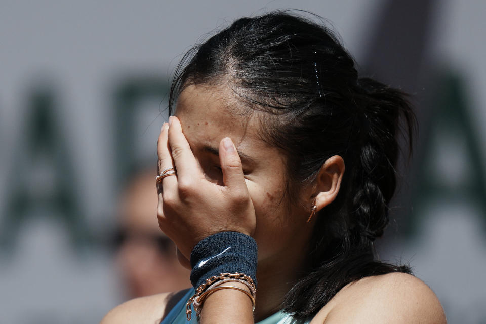 Britain's Emma Raducanu hides her face as she plays Aliaksandra Sasnovich of Belarus during their second round match of the French Open tennis tournament at the Roland Garros stadium Wednesday, May 25, 2022 in Paris. (AP Photo/Thibault Camus)