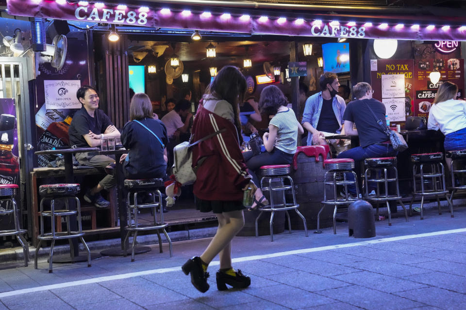 People gather at a bar after government imposed 8 p.m. closing time for restaurants and bars under Tokyo's fourth state of emergency Saturday, July 17, 2021, in Tokyo. The latest state of emergency has asked restaurants and bars to close by 8 p.m., if not entirely. This has pushed people to drink outside, although many bars remain open and bustling with customers who are defying the rules and expressing frustration and indifference. (AP Photo/Kiichiro Sato)