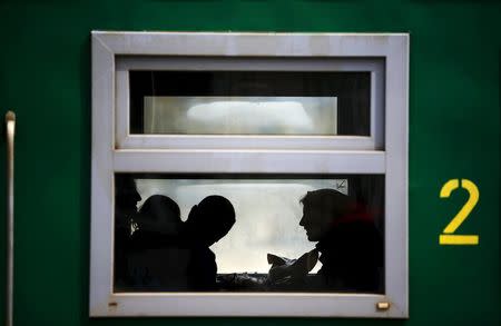 Passengers are seen silhouetted inside a train at Velingrad railway station, Bulgaria April 28, 2015. REUTERS/Stoyan Nenov