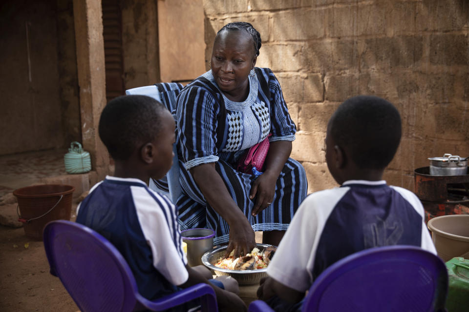 Mariama Sawadogo, 44, who works as a radio host at Zama Radio, prepares lunch at her home in Kaya, Burkina Faso, Monday, Oct. 25, 2021. Many guests and listeners in Burkina Faso call her "aunty" as she gently guides them to the right answers and awards prizes such as soap and washing buckets. In the West African country of Burkina Faso, many feel the government has let them down during the pandemic. Tests, vaccines and messaging often miss many residents, despite a $200 million budget for virus-response efforts. In a region where women are responsible for family work and community relationships, they’ve stepped up to fill in gaps. (AP Photo/Sophie Garcia)