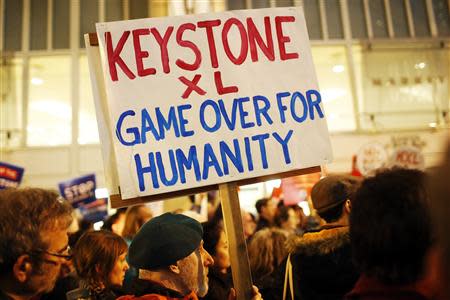 A demonstrator holds a sign in protest against the proposed Keystone XL oil pipeline in San Francisco, California, in this February 3, 2014 file photo. REUTERS/Stephen Lam/Files