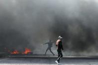 Iraqi demonstrators burn tires during ongoing anti-government protests in Basra