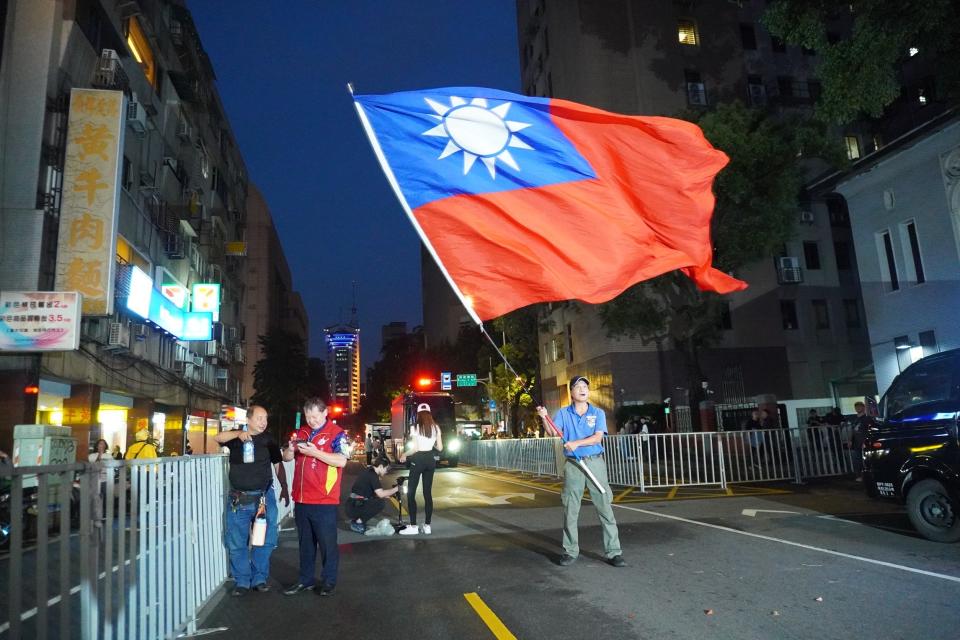 由贊成方申請路權的青島東人數稀落，男子揮舞巨幅國旗。林泊志攝