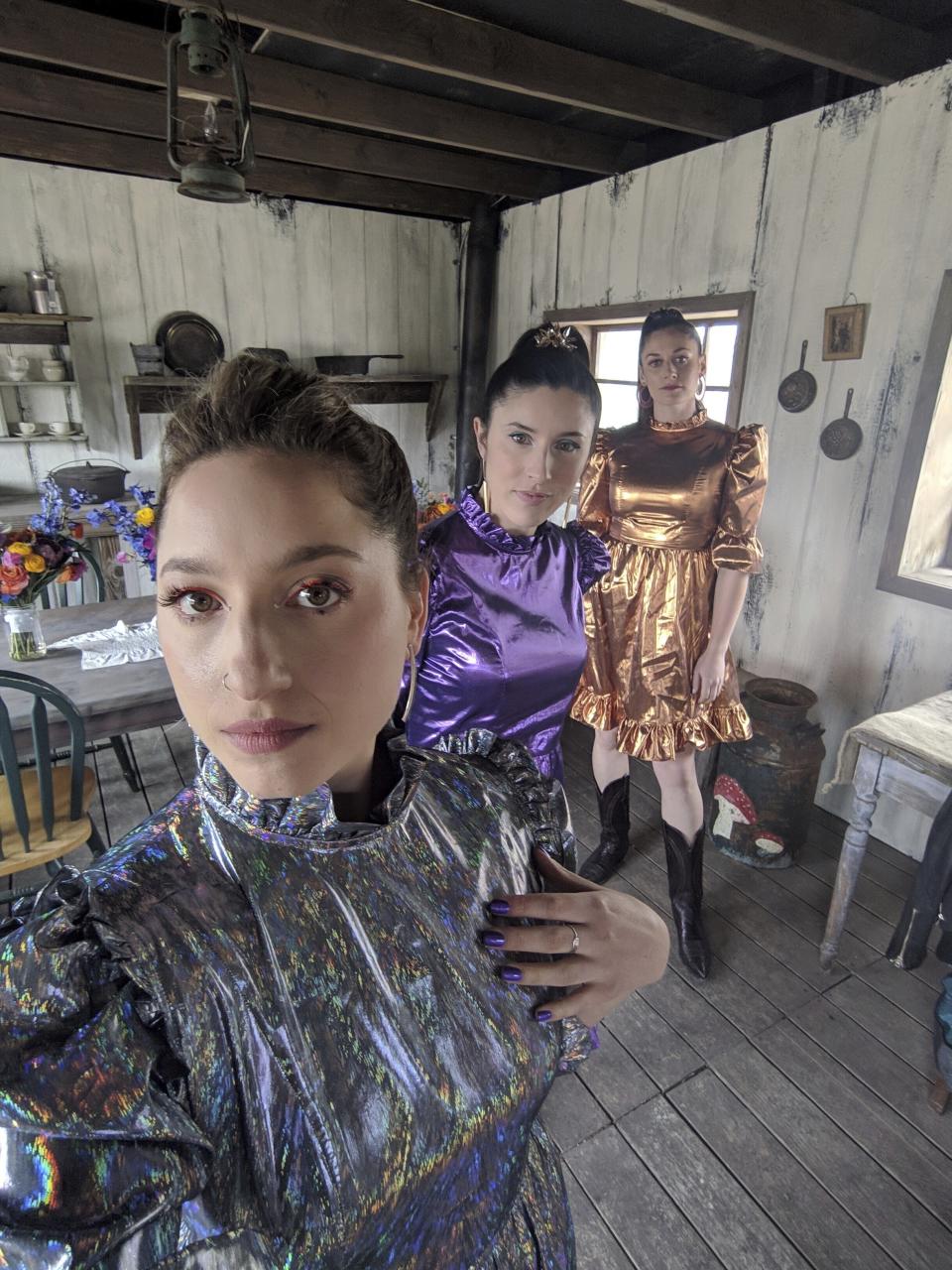 Rikki Gotthelf, from left, Laura Macshane, center, and Zoe Cohen appear at a wedding in Austin, Texas on March 30, 2019. The three were bridesmaids for the wedding of a friend in an abandoned ghost town. The guest dress code was “Space Cowboy Disco.” (Rikkie Gotthelf via AP).