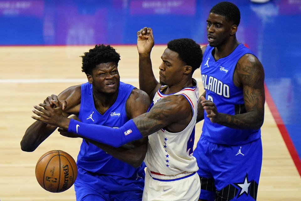 Orlando Magic's Mo Bamba, left, cannot get a shot past Philadelphia 76ers' Paul Reed, center, as Dwayne Bacon looks on during the second half of an NBA basketball game, Sunday, May 16, 2021, in Philadelphia. (AP Photo/Matt Slocum)