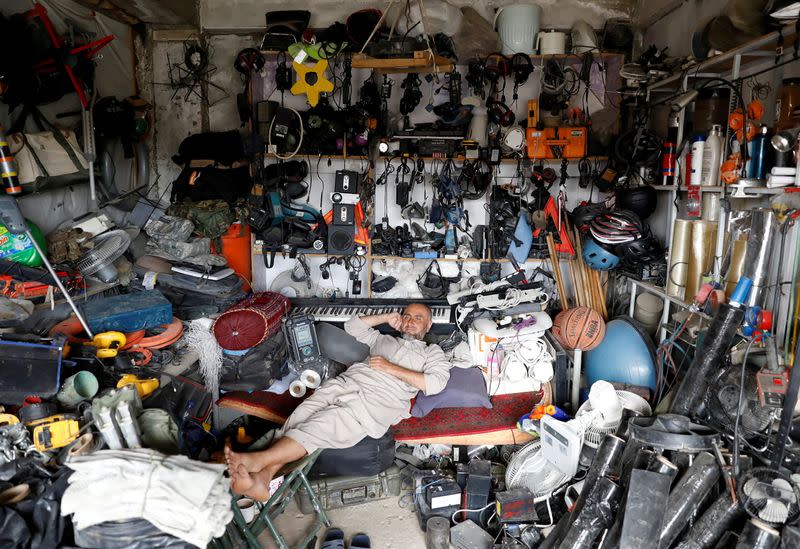 An Afghan man rests in his shop as he sell U.S. second hand materials outside Bagram U.S. air base, after American troops vacated it, in Parwan province