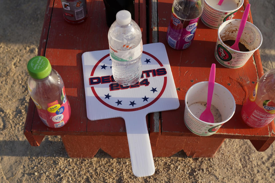 A campaign fan for Republican presidential candidate Florida Gov. Ron DeSantis sits on a bench during a campaign stop at the Field of Dreams movie site, Thursday, Aug. 24, 2023, in Dyersville, Iowa. (AP Photo/Charlie Neibergall)